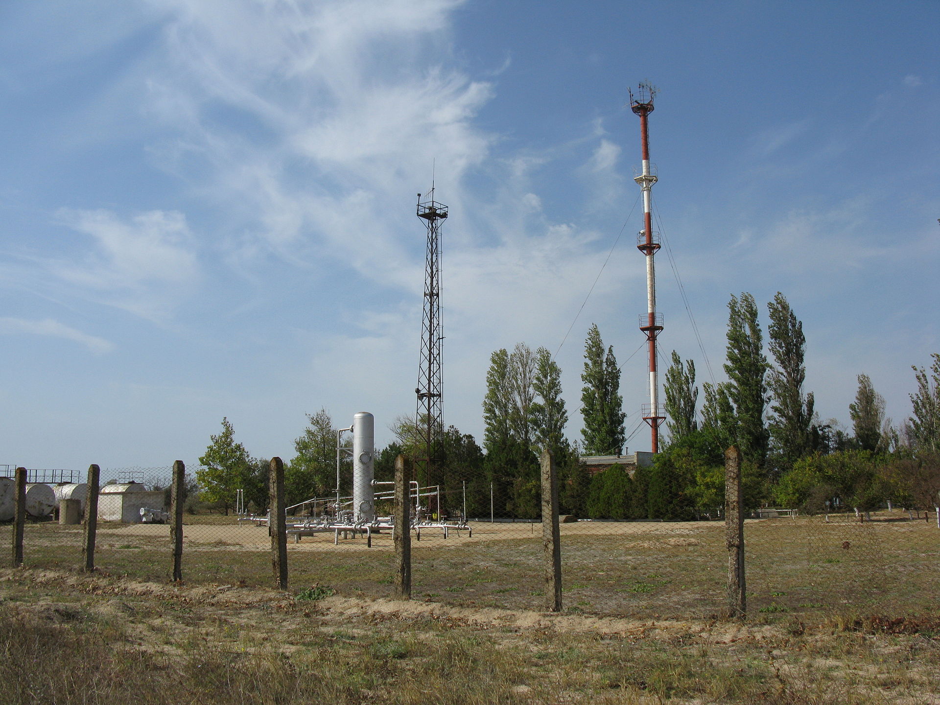 Gas compressor station with stacks in an open field