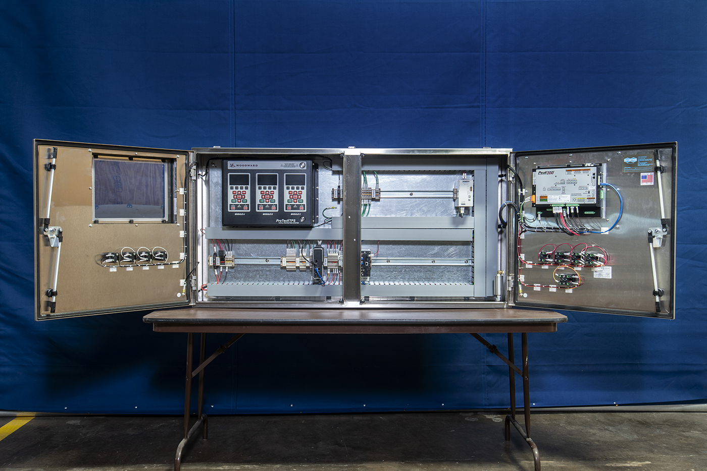 Two open stainless-steel control enclosures showing internal components