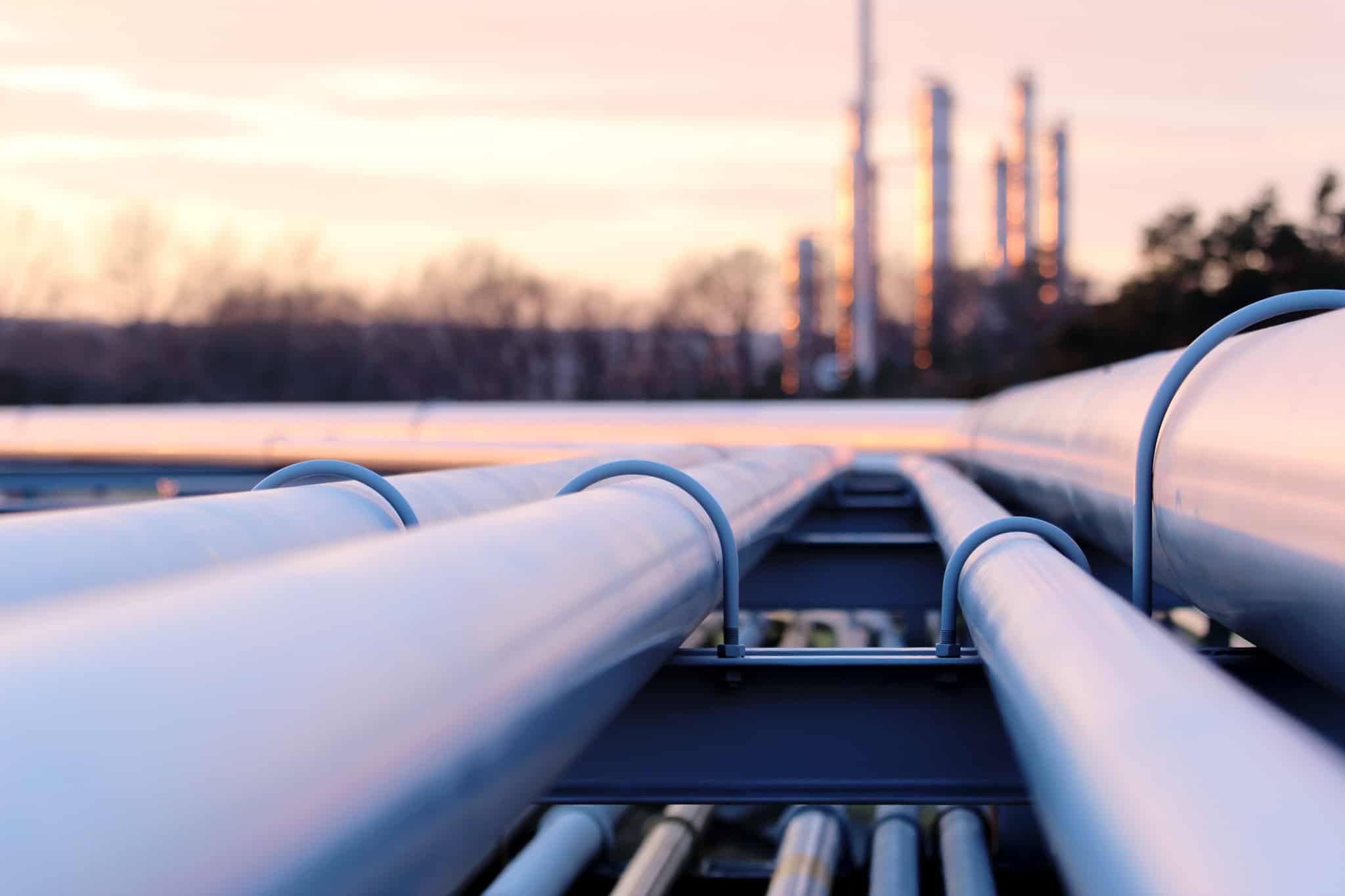 Pipelines leading to a gas processing facility at dusk